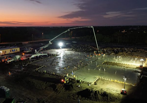 Twilight commercial slab pour with a concrete pump truck and anchor bolts set